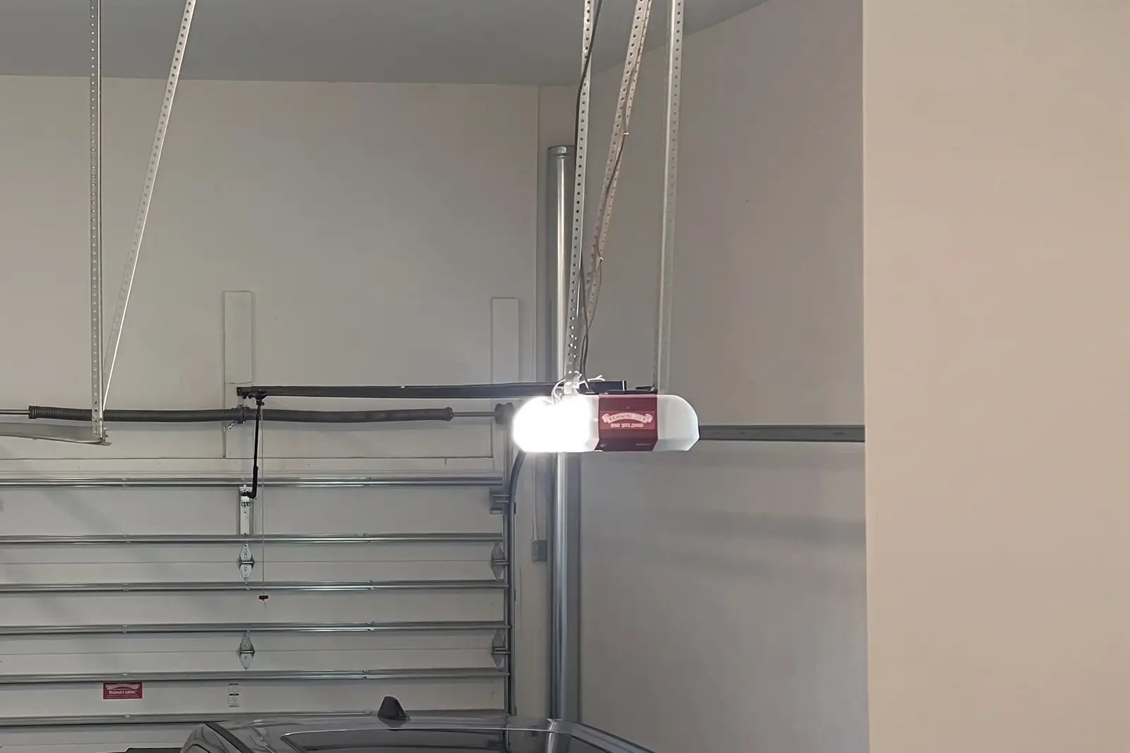 Garage door opener rail and motor unit mounted to the ceiling