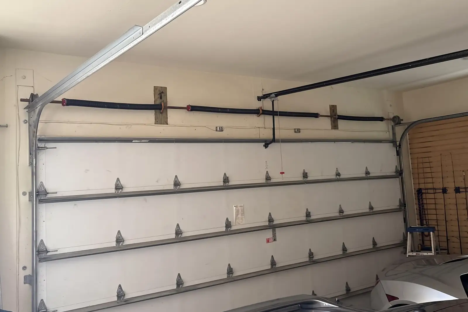 Close-up of a torsion spring and shaft above a garage door