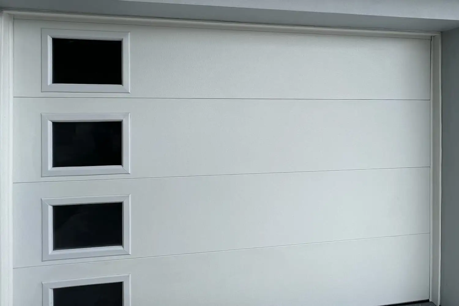 White flush garage door with a column of four small windows