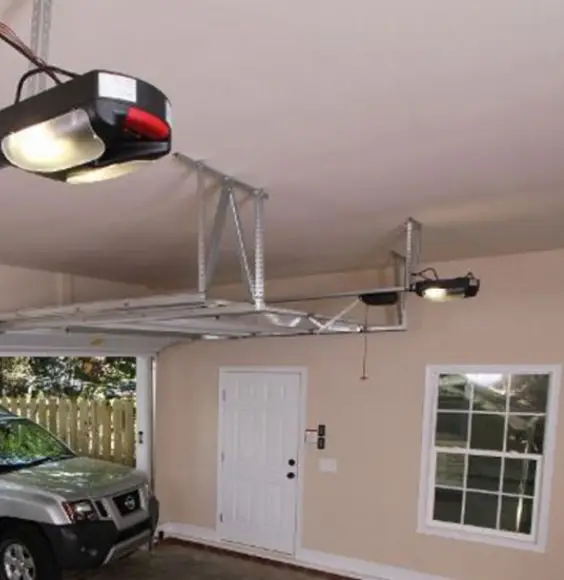 Ceiling-mounted garage door opener and rail in a two-car garage, with one door open