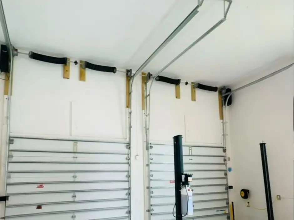 Two-car garage interior with both doors, their tracks and springs freshly installed
